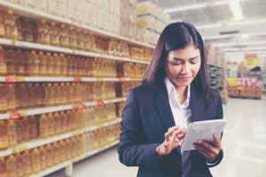 Businesswoman using mobile digital tablet to check the product quality in the supermatket